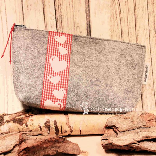 Handgenähte weidräwöl Kosmetiktasche aus hellgrauem Filz mit Herzen und rotem Karoband.