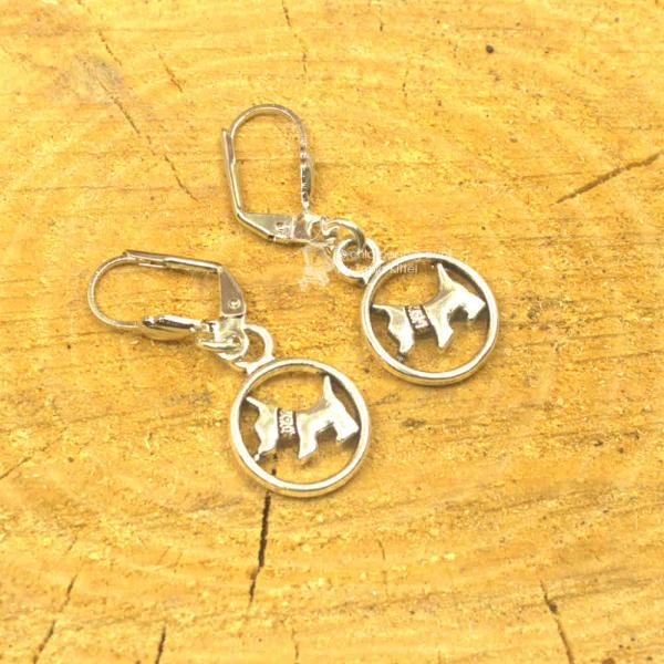 Die versilberten Ohrringe als Hänger mit kleiner Hund