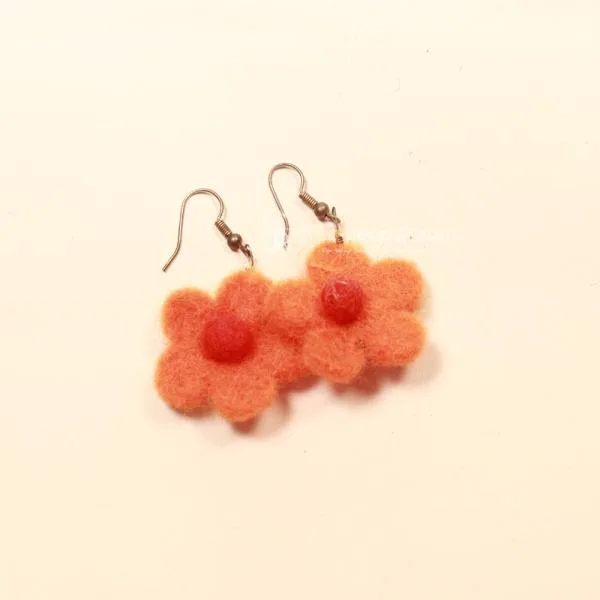 Handgefertigte Blumen-Ohrringe aus orange-rotem Filz mit versilberten Fischhaken-Verschlüssen.
