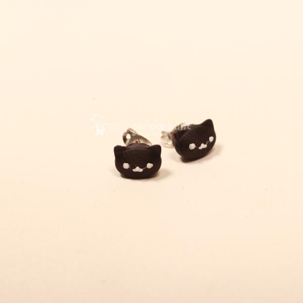 Kleine, schwarze Katzenkopf-Ohrringe, verarbeitet als versilberte Ohrstecker im filigranen Design von chic-peppig-bunt.