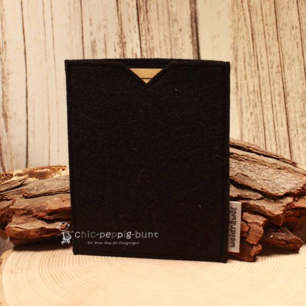 Schwarze handgenähte Filz Passhülle der Marke Weidräwöl für Reisepass und Impfpass auf hellem Untergrund.