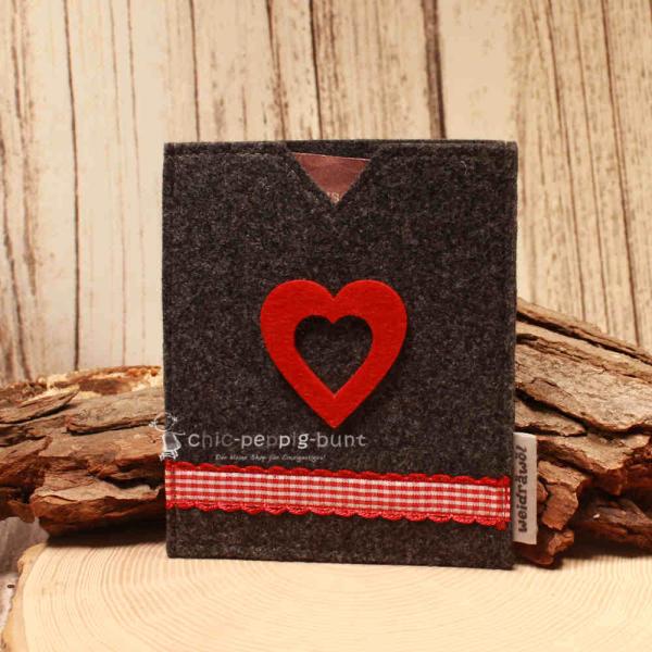 Handgenähte dunkelgraue Filz Passhülle der Marke Weidräwöl mit rot-weiß karierter Bordüre und rotem Filzherz für Reisepass und Impfpass.