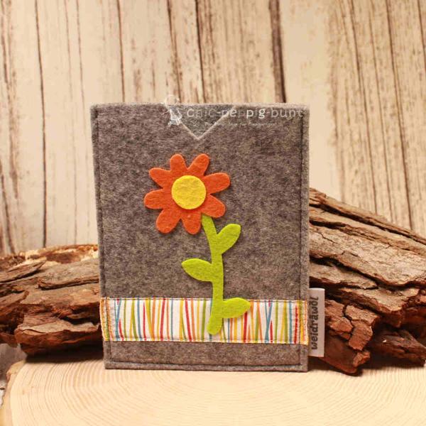 Handgenähte hellgraue Filz Passhülle der Marke Weidräwöl mit oranger Blumen-Applikation und bunt gestreifter Bordüre für Reisepass und Impfpass.