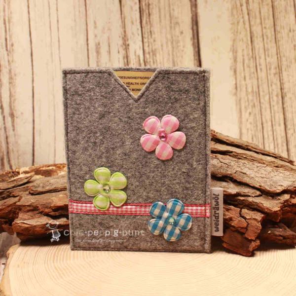 Handgenähte hellgraue Filz Passhülle der Marke Weidräwöl mit drei karierten Blumen-Applikationen und rot-weißer Karobordüre für Ausweise.