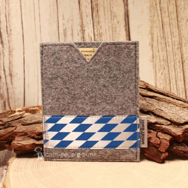 Handgenähte hellgraue Filz Passhülle der Marke Weidräwöl mit blau-weißer Bordüre im Bayern-Design für Reisepass und Impfpass.