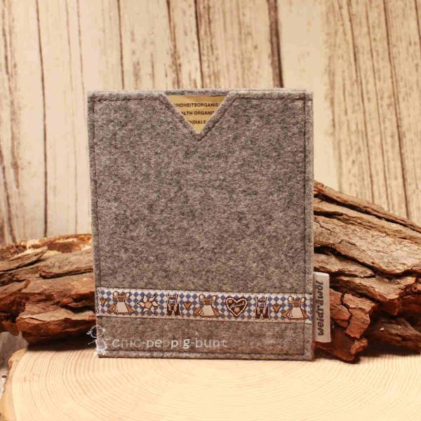 Handgenähte hellgraue Filz Passhülle der Marke Weidräwöl mit blau-weißer Trachtenbordüre für den Schutz von Reisepass und Impfpass.