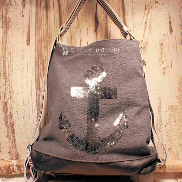 Grauer Rucksack aus Stoff mit silbernem Anker aus Pailletten, braunem Lederboden und gestreiften Gurten, 3-in-1 Funktion als Handtasche.