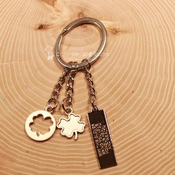 Detailaufnahme der Gravur "May the clover bring you love" auf dem Metall-Taschenanhänger.