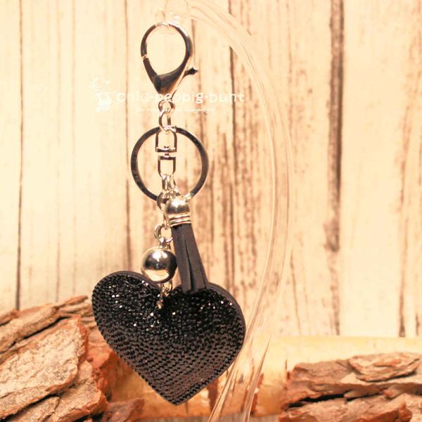 Detailaufnahme der Glitzerseite des Herz-Taschenanhängers mit Metallperle und Schlüsselring.