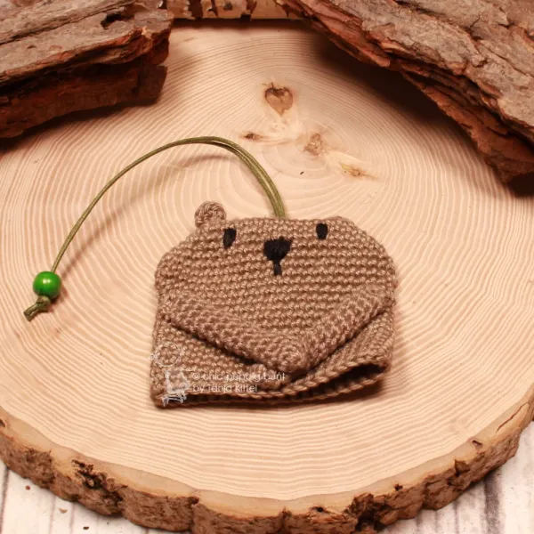 Handmade Bären Schlüsselanhänger aus Wolle mit grüner Holzperle auf einer dekorativen Holzscheibe