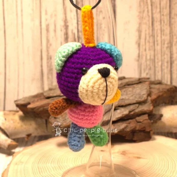 Handgemachter gehäkelter Bär in lila/rosa als unisex Glücksbringer. Fair Trade Wolle, 11×7×6 cm.
