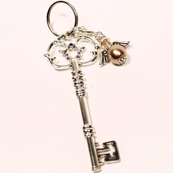 Detailaufnahme Schlüsselanhänger goldener Vintage-Schlüssel mit abnehmbarem Engel-Charm und Strass auf Holzgrund – Handgefertigt von chic-peppig-bunt Deutschland.