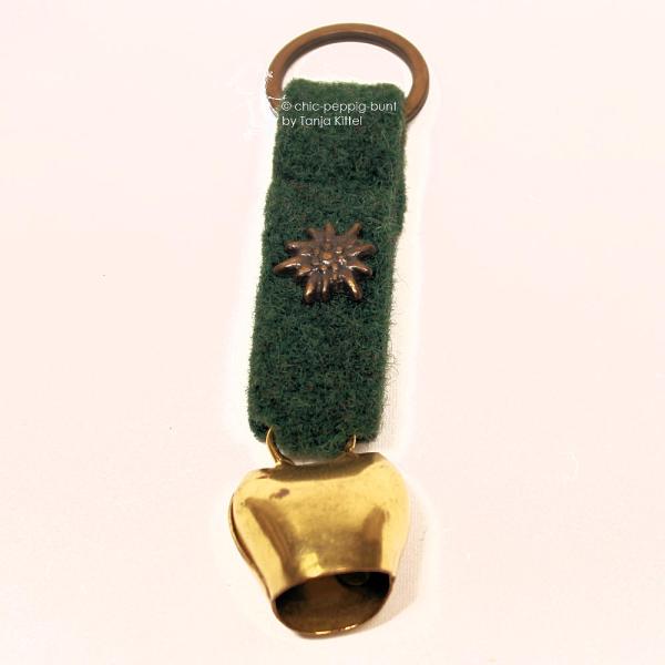 Grüner Trachten-Schlüsselanhänger aus Filz mit kleiner goldener Kuhglocke und detailliertem Edelweiß-Metall-Charm – Handarbeit von chic-peppig-bunt.