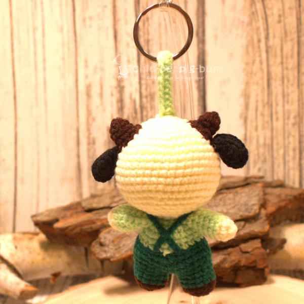 Nahaufnahme des gehäkelten Kuh-Taschenbaumlers aus Wolle. Gesamthöhe 16 cm, World Fair Trade. Nahaufnahme des gehäkelten Kuh-Taschenbaumlers aus Wolle. Gesamthöhe 16 cm, World Fair Trade.