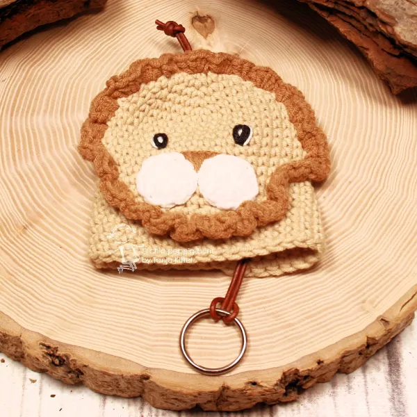 Handmade Löwen Schlüsselanhänger Rückseite mit hellrosa Perle auf einer Holzscheibe dekoriert