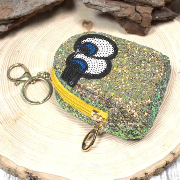 Gelbes Glitzer-Schlüsselmäppchen mit Augen-Motiv, geschlossen, frontal.