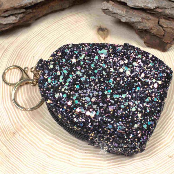 Die 17 cm Gesamthöhe des Mäppchens mit Schlüsselring, Fokus auf das glitzernde Stoffmaterial.