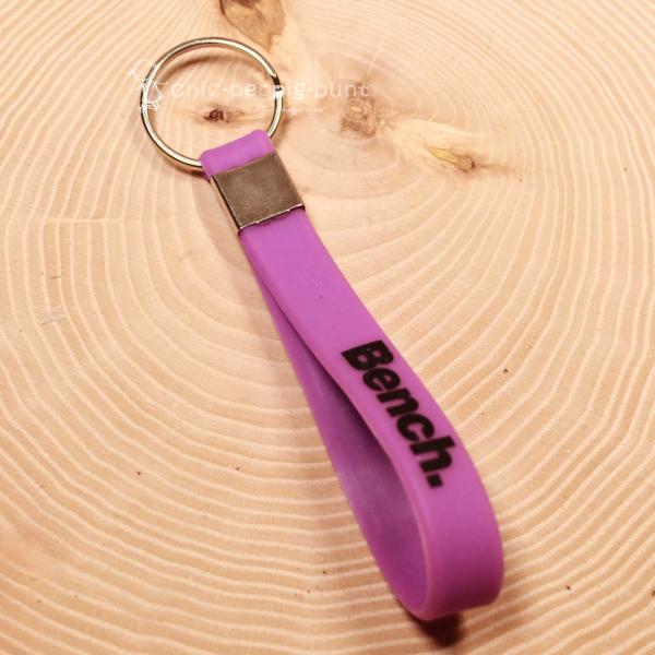 Sportlicher Bench Schlüsselanhänger aus schwarzem PVC-Band mit weißem Schriftzug und Metallring.