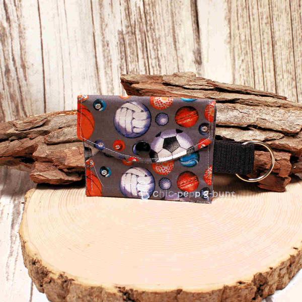 Handgenähtes farbenfrohes Schlüsselmäppchen von chic-peppig-bunt mit Kunststoff-Druckknopf und silbernem Schlüsselring auf hellem Hintergrund.