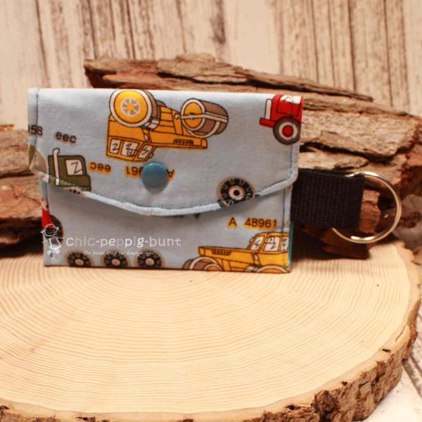 Handgenähtes farbenfrohes Schlüsselmäppchen von chic-peppig-bunt mit Kunststoff-Druckknopf und silbernem Schlüsselring auf hellem Hintergrund.