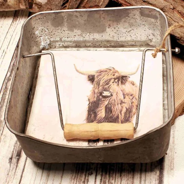 Shabby-Chic Serviettenständer aus Blech mit eingelegter Motivserviette eines Hochlandrinds.