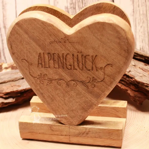 Rustikaler Holz-Serviettenständer im alpinen Trachtenstil mit detaillierten floralen Gravuren.