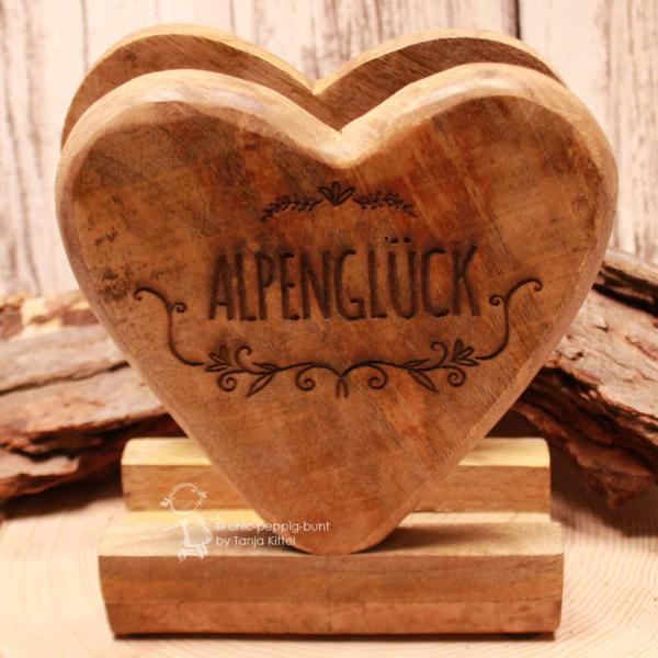 Rustikaler Serviettenspender aus Holz in Herzform mit dunkel eingebranntem Schriftzug Alpenglück.