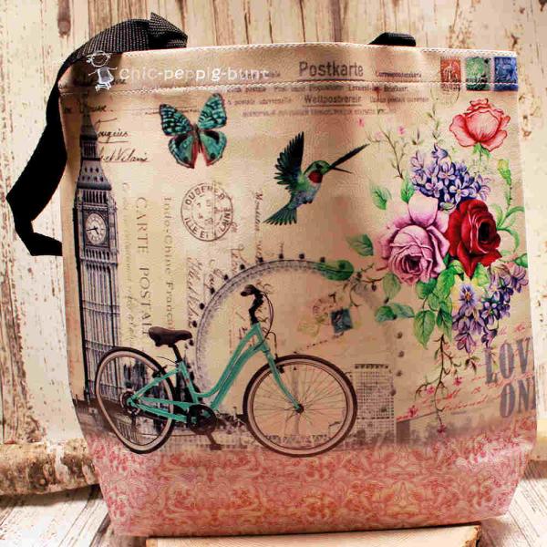 Große Shoppertasche aus rosa Kunstleder mit cremefarbenen Details, langem Schulterband und hellem Innenfutter vor hellem Hintergrund.