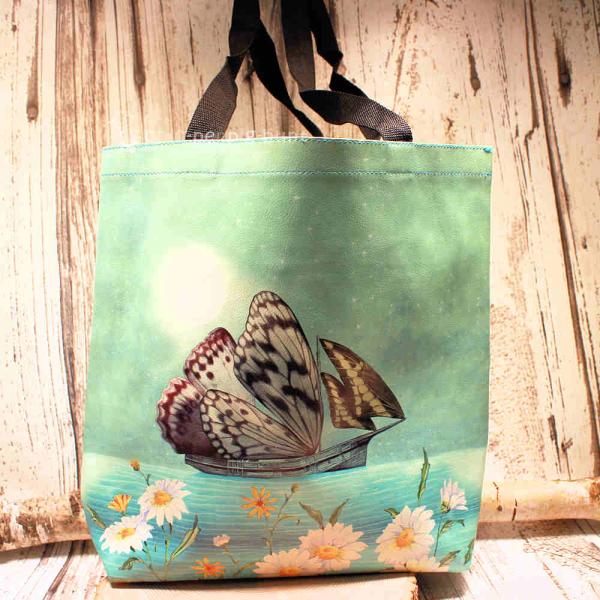 Große grüne Shoppertasche aus Kunstleder mit sichtbarem pinken Innenfutter, langem Schulterriemen und Reißverschlussfach auf hellem Hintergrund.