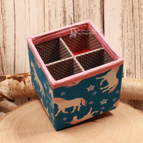 Draufsicht auf die Einhorn-Ordnungsbox mit flachem Fach für Kleinteile wie Radiergummis.