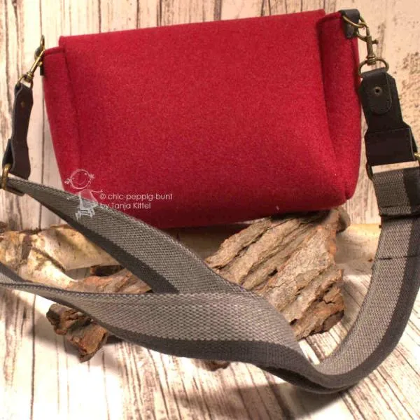 Rote Filz Handtasche quer getragen, zeigt die Maße und das kompakte Design.