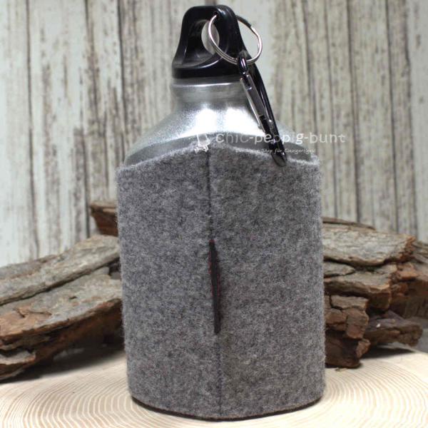 Nahaufnahme der hellgrauen Trinkflasche  und der feinen Stickerei des Hirsch-Motivs Nahaufnahme der hellgrauen Trinkflasche  und der feinen Stickerei des Hirsch-Motivs