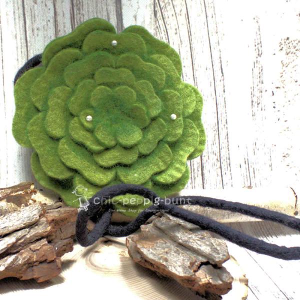 Runde grüne Umhängetasche aus Filz in Blumenform mit Perlenverzierung und Reißverschluss.