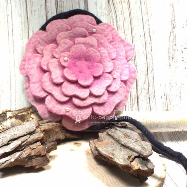 Runde rosa Umhängetasche aus Filz in Blumenform mit glitzernden Perlen und sicherem Reißverschluss.
