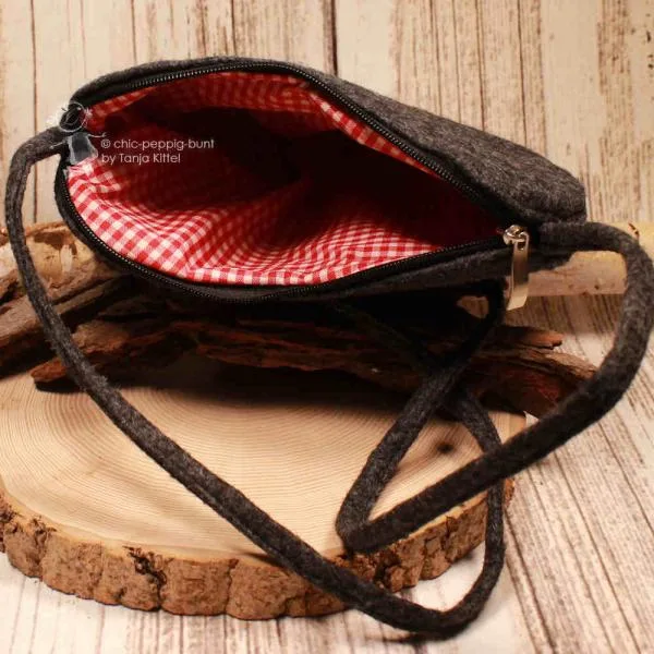 Geöffnete Herz-Handtasche mit Blick auf das rot-weiß karierte Innenfutter.