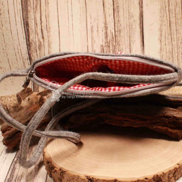 Innenansicht der Herz-Filztasche mit rot-weiß kariertem Futter und offenem Reißverschluss.