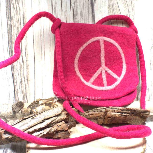 Quadratische pinke Umhängetasche aus handgefertigtem Filz mit weißem Peace-Zeichen, Umschlagklappe und langem Schulterband.
