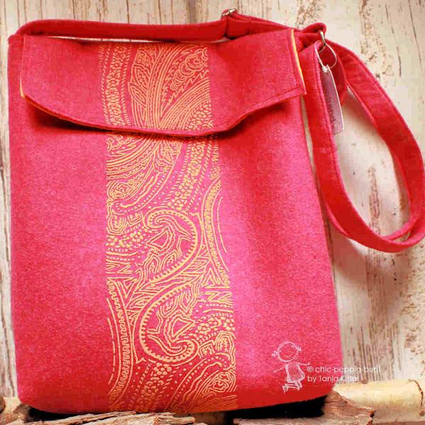 Große pinke Umhängetasche aus Filz mit verstellbarem Schultergurt, Magnetknopf und praktischer Innenaufteilung.