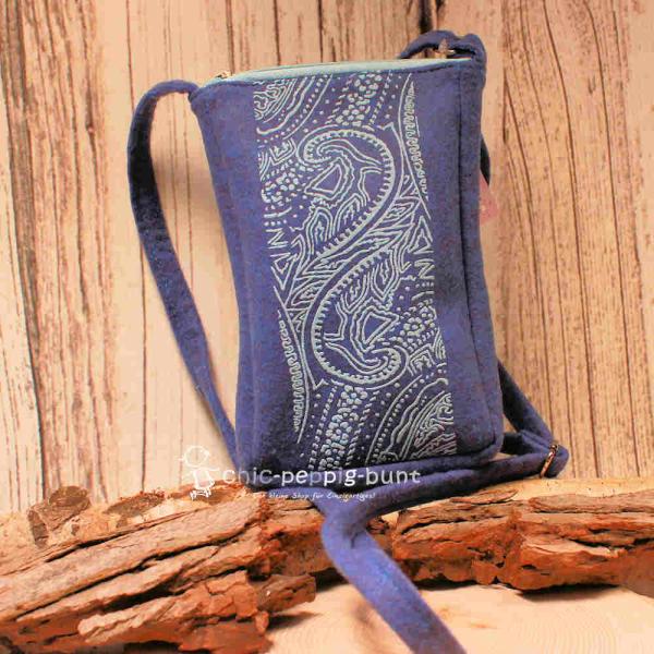 Blaue Filz-Umhängetasche für Damen mit Reißverschluss und extrem langem, verstellbarem Schultergurt auf hellem Hintergrund.