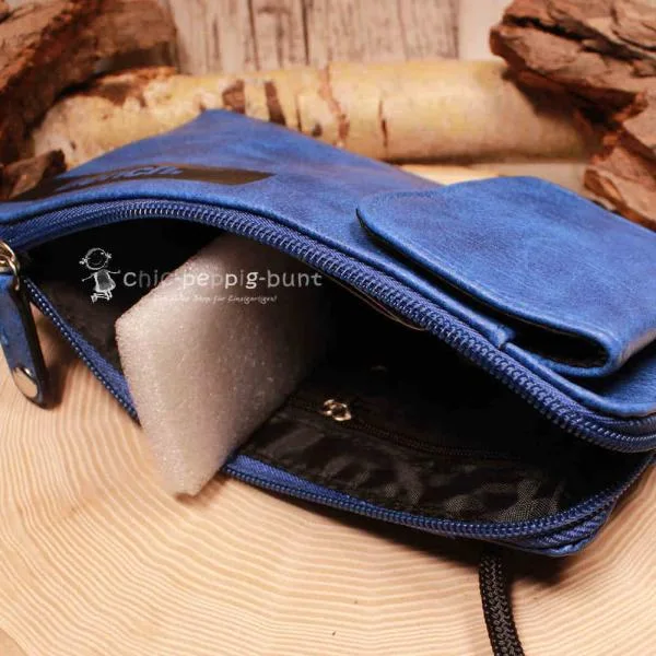 Geöffnete blaue Handtasche mit Blick auf 4 Kartenfächer und das Münzfach.