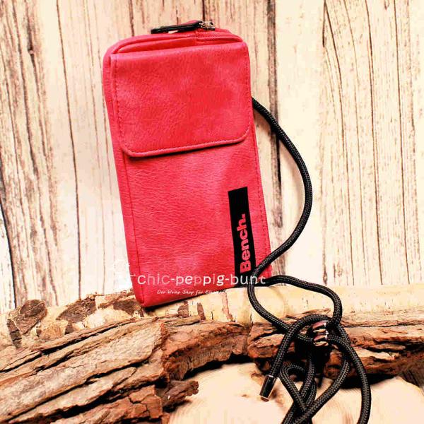 Bench Handytasche aus pinkem Leder mit Smartphone im Außenfach und Magnetverschluss.