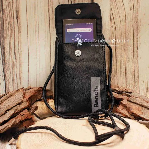 Geöffnete schwarze Leder Umhängetasche mit eingeschobenem Smartphone im Frontfach.