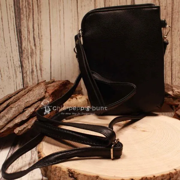 Schwarze Leder-Umhängetasche als Crossbody-Bag getragen mit maximaler Gurtlänge.