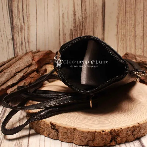 Geöffnetes Fach der schwarzen Ledertasche mit hochwertigem Innenfutter.