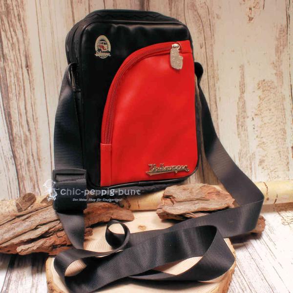 Rot-schwarze VW T1 Umhängetasche aus Kunstleder mit Reifenprofilkante und silbernem 3D Volkswagen-Schriftzug.