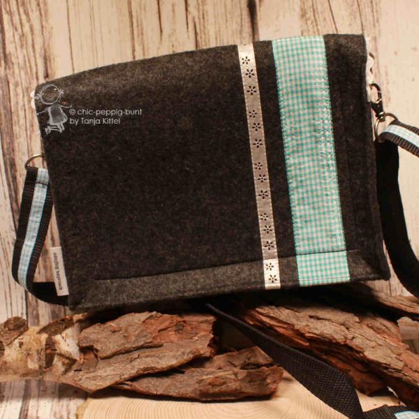 Rückseite der Filztasche mit Fokus auf die senkrecht verlaufenden Zierbordüren und das seitliche Stoff-Label.