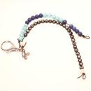 Handgefertigte blaue Rechenkette und ABC Kette mit Fahrradanhänger und Namen als Schultaschenanhänger auf weißem Hintergrund.