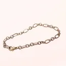 Ausgebreitetes versilbertes Bettelarmband aus Metall mit Wechselmuster aus runden und rechteckigen Gliedern sowie Karabiner-Verschluss.