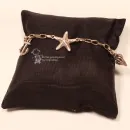 Versilbertes Bettelarmband aus Metall mit großen Gliedern auf einem braunen Schmuckkissen präsentiert.