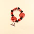 Handgefertigtes elastisches Halloween-Armband mit großen orangefarbenen Kürbisperlen und silberfarbenem Hexenhut-Anhänger.